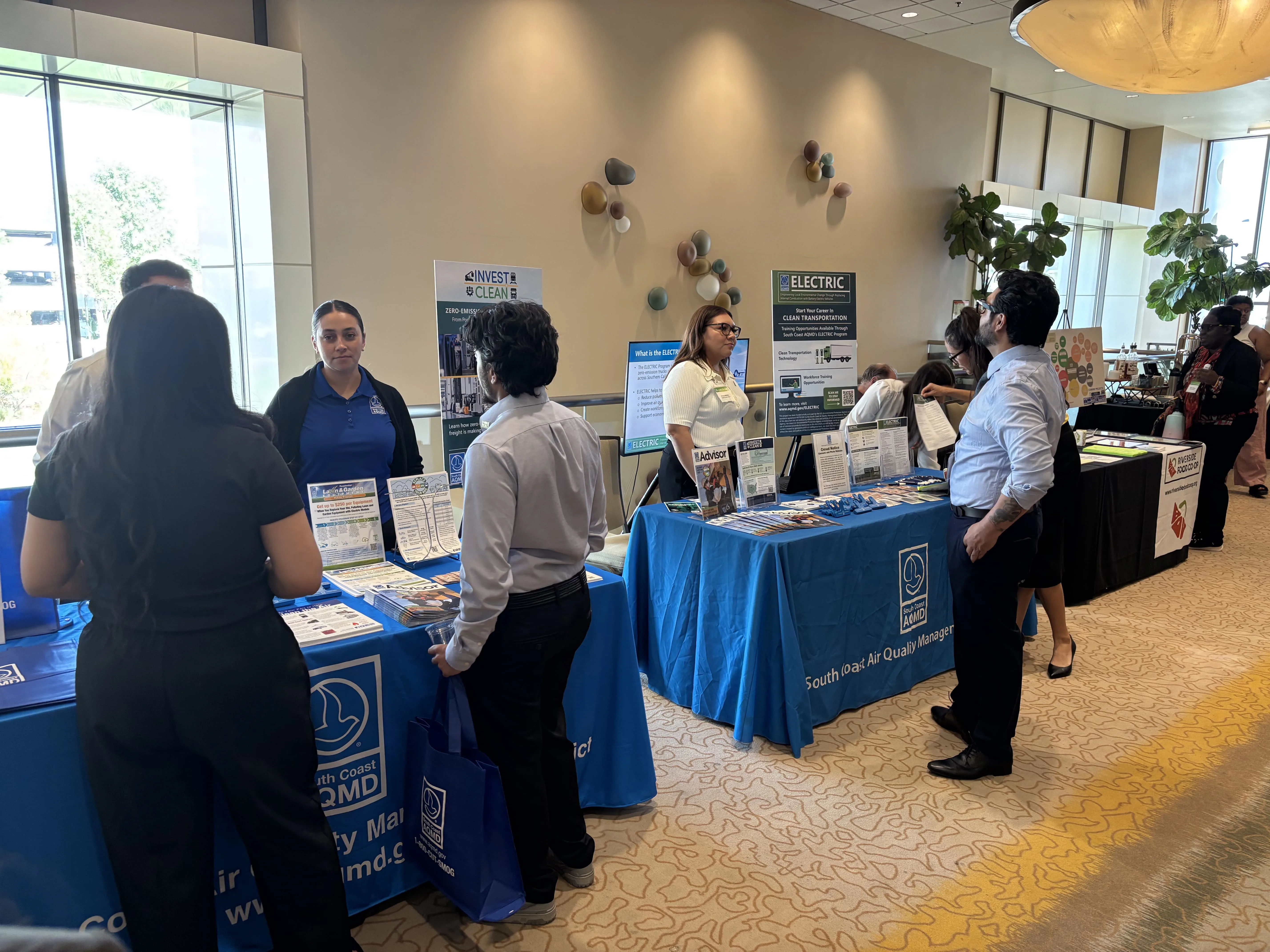 Multiple INVEST CLEAN and electric transportation booths at a regional event